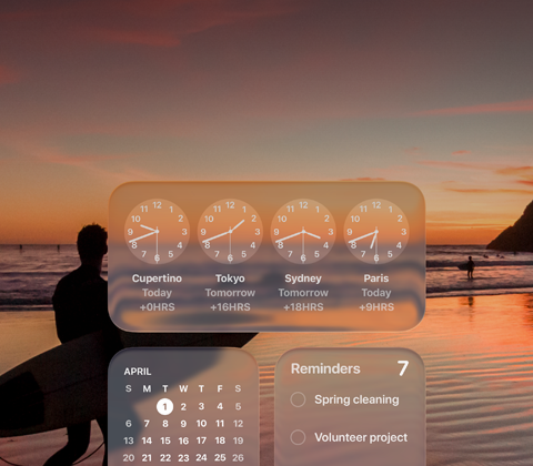 Widget Liquid Glass Jam, Kalender, Pengingat, dan Cuaca di layar macOS Tahoe, di atas gambar seorang peselancar yang berjalan di pantai saat matahari terbenam