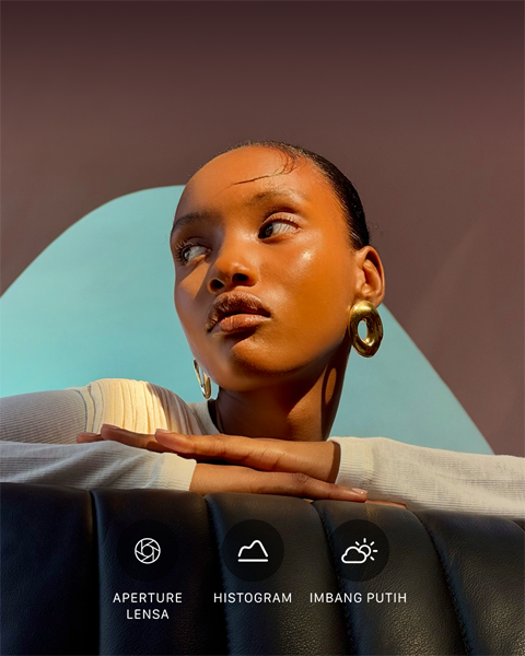 Potret close up seorang model dengan pencahayaan terang dan latar belakang penuh warna, menunjukkan UI kontrol Pro pada sistem kamera pro: Aperture, Histogram, Imbang Putih