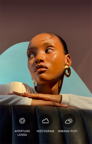 Potret close up seorang model dengan pencahayaan terang dan latar belakang penuh warna, menunjukkan UI kontrol Pro pada sistem kamera pro: Aperture, Histogram, Imbang Putih