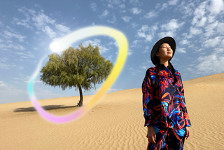 iPad Pro, layar eksterior depan dengan latar belakang gradien biru tua dan hijau dengan beberapa aplikasi terbuka, tangan memegang Apple Pencil Pro yang melingkari sketsa yang menampilkan fitur Apple Intelligence Image Wand