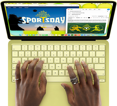 MacBook Neo, warna citrus, tangan di keyboard, pengguna sedang mengetik undangan email ke sebuah acara pembukaan pameran seni, situs web untuk acara tersebut terbuka di samping