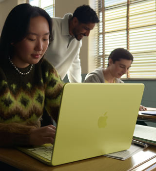 Seorang mahasiswa menggunakan MacBook Neo, warna citrus, tidak dicolok di ruang kelas
